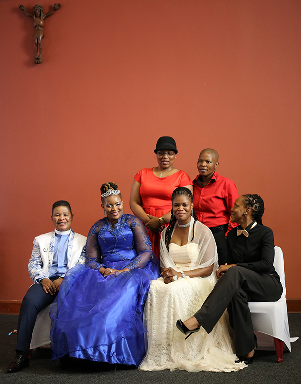 Pastor Zungu (far left) and wife MaGesh (femme in royal blue dress). They have 2 children. 